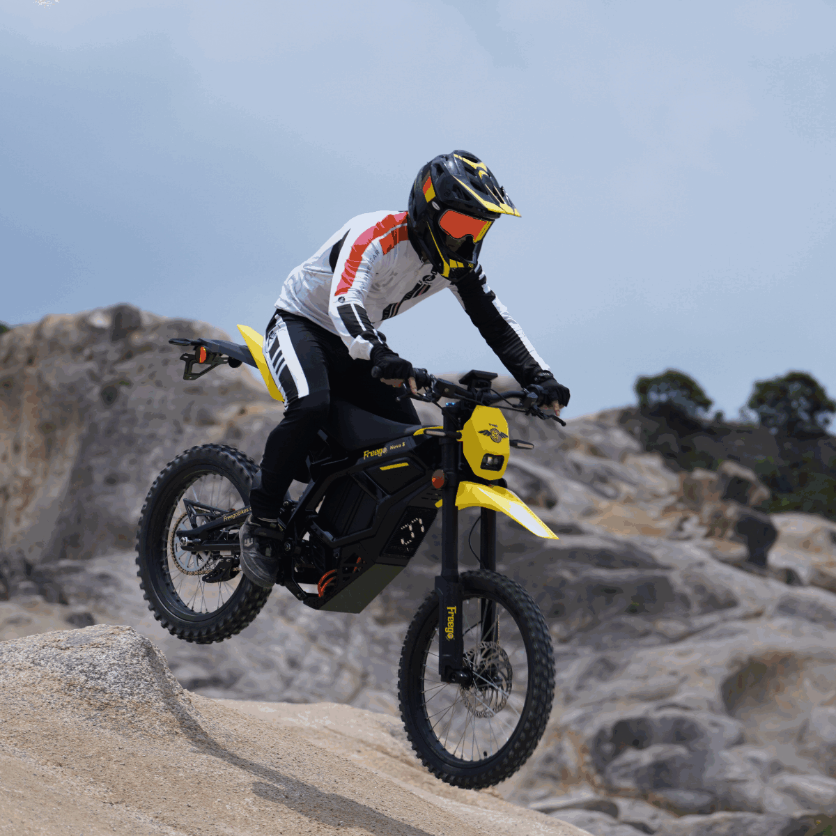 Rider jumping on Freego Nova 5 electric dirt bike over rocky terrain