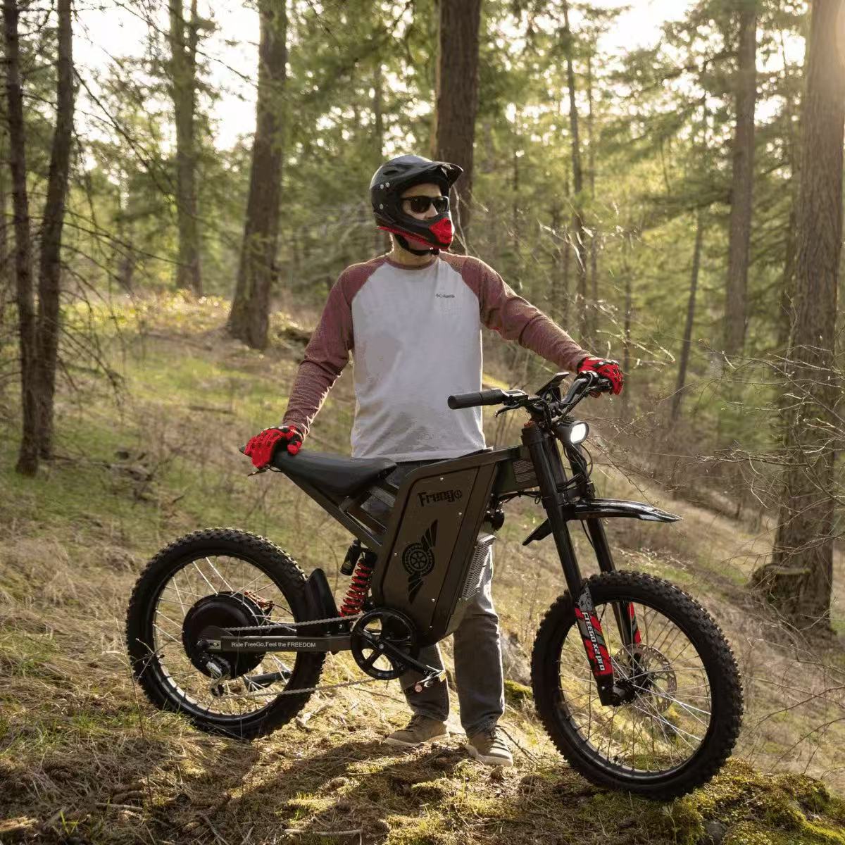 Person with a helmet and gloves standing next to an electric bike in a forest